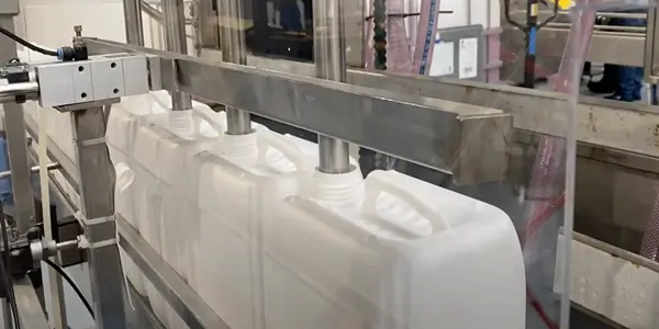 Weiße Kanister auf der Abfüllanlage für chemisch-technische Produkte