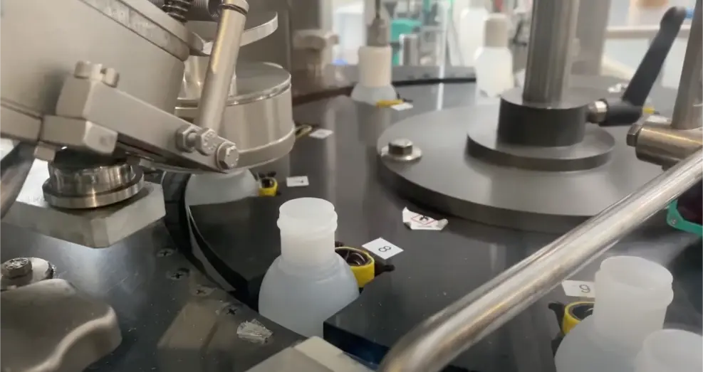 Kleine weiße Flaschen auf der Rundläuferanlage bei der Abfüllung von Bioziden